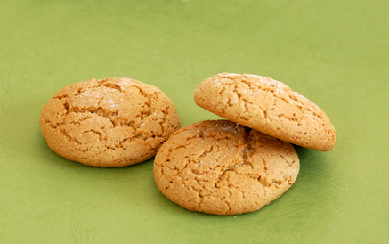 three fresh appetizing oatmeal cookies over green background