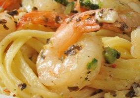Closeup of shrimp scampi with sauteed garlic, lemony sauce and broccoli