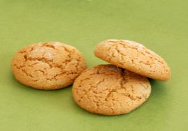 three fresh appetizing oatmeal cookies over green background