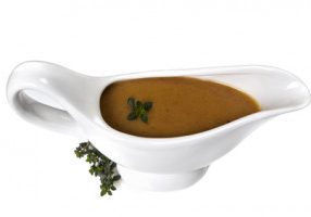 Thyme gravy in white gravy boat, isolated.  Delicious!